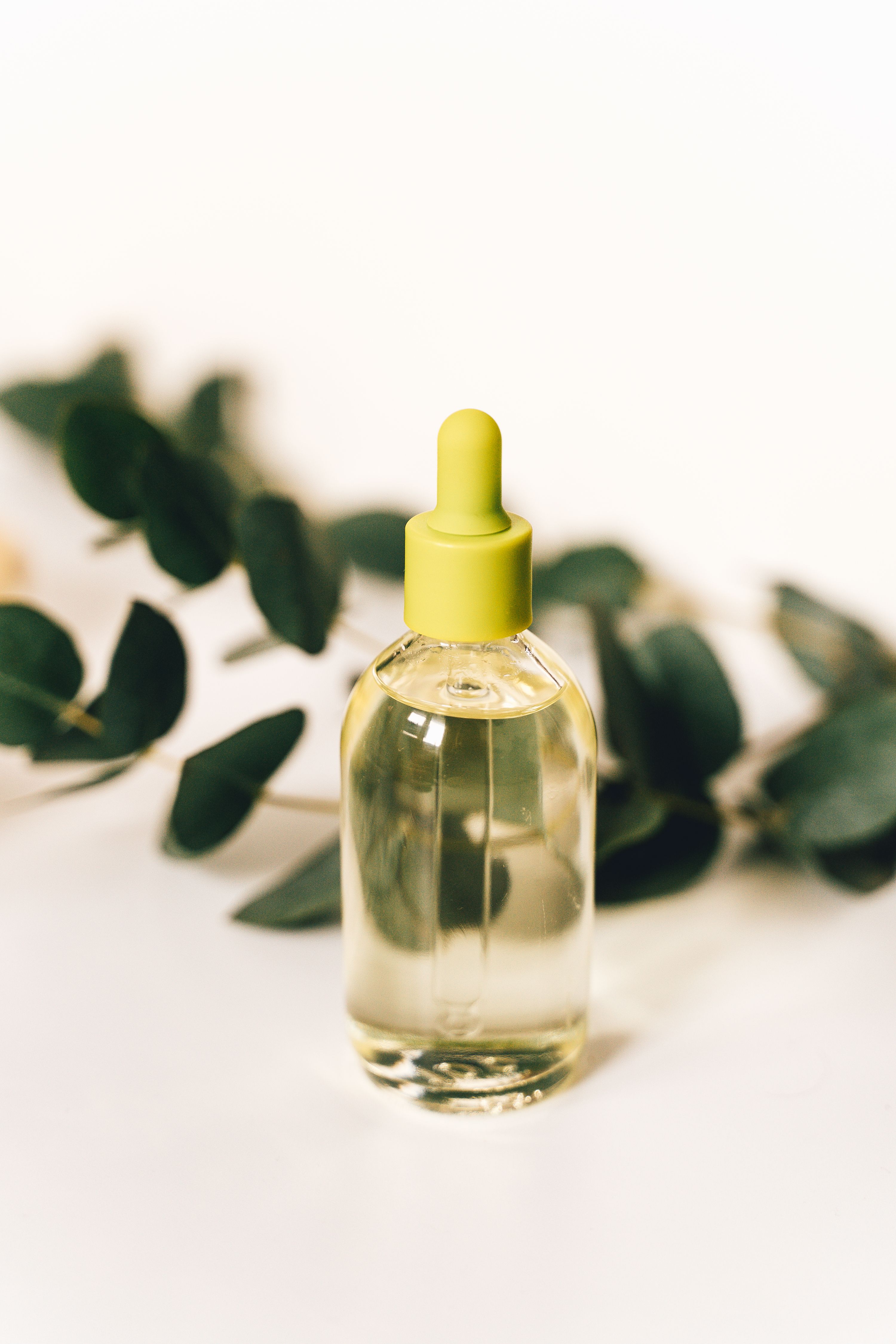 A bottle of clear base oil on a pale background