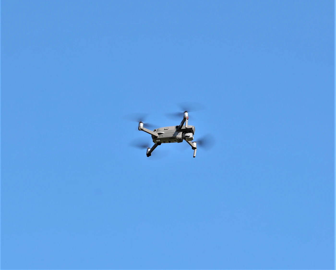 An inspection drone in flight against a clear sky
