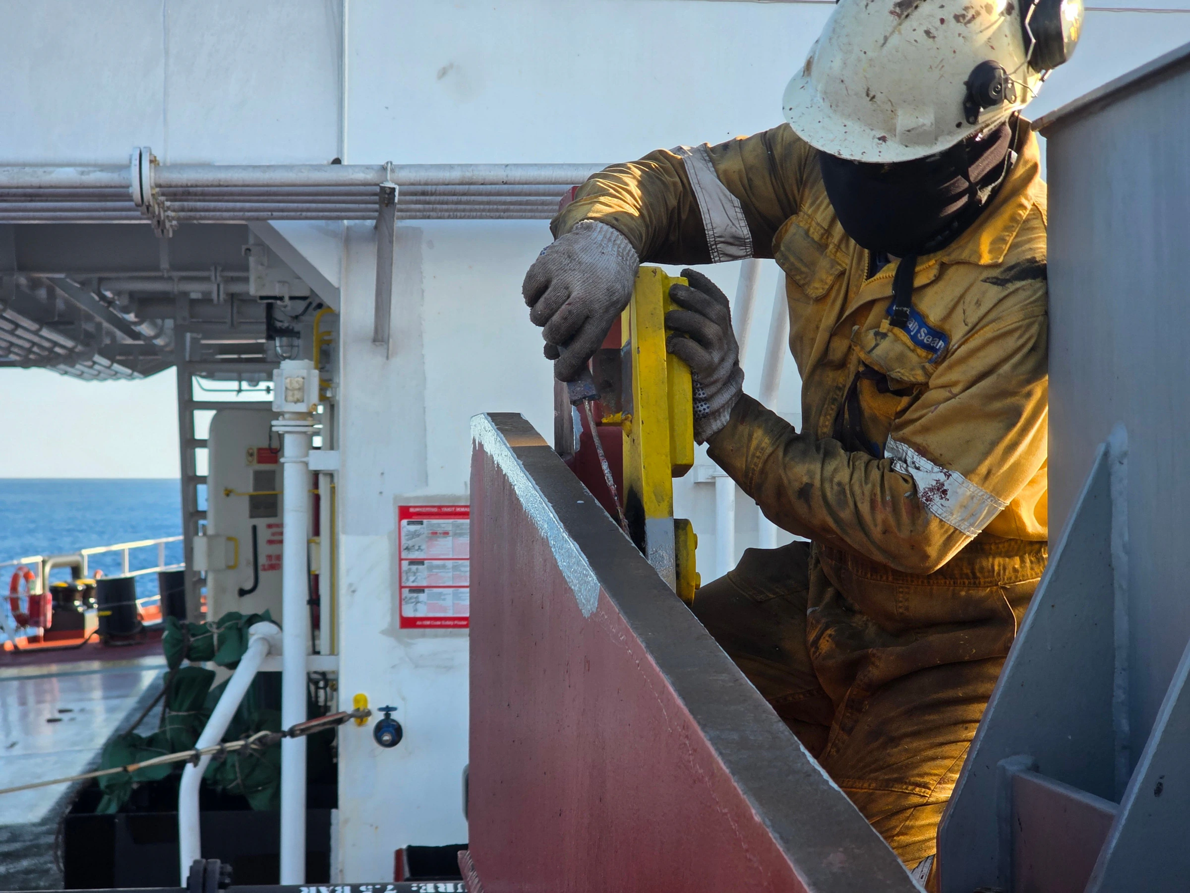 A crew member securing equipment on a vessel deck