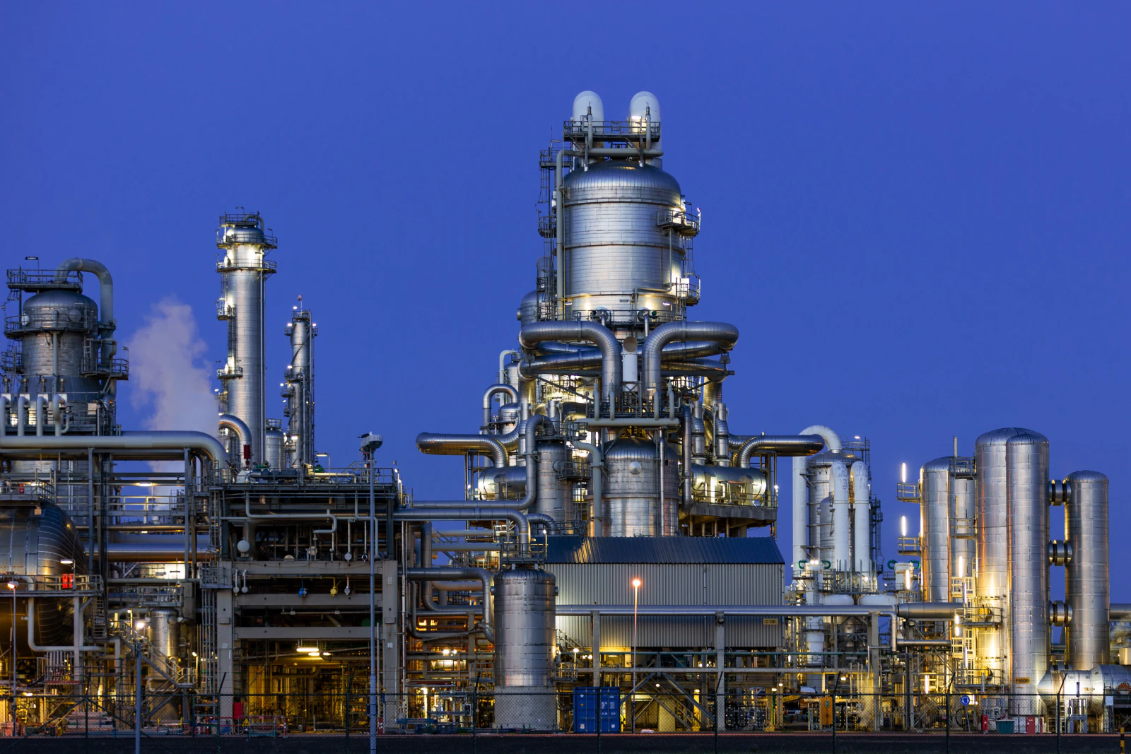 A processing facility lit against a dusk sky