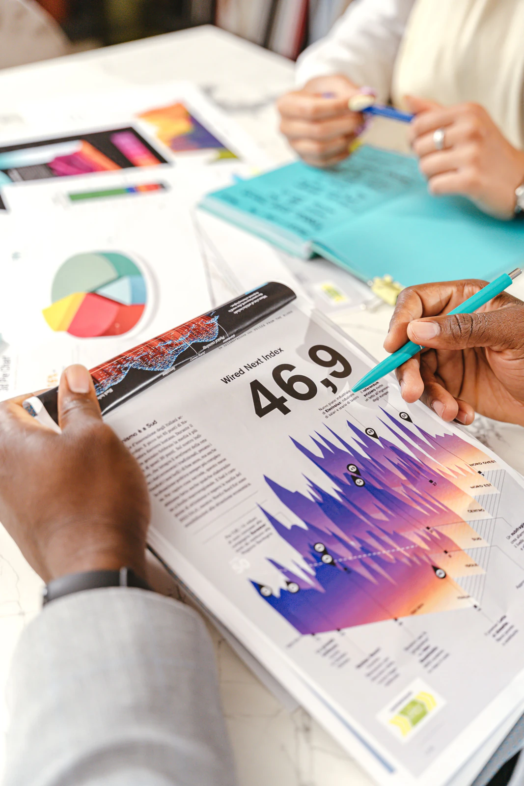 Hands annotating printed charts and data reports